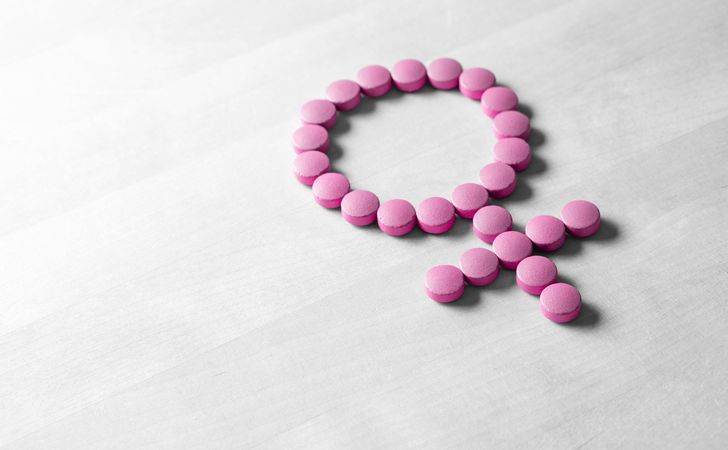 ピンクの錠剤で女性の記号がつくられている